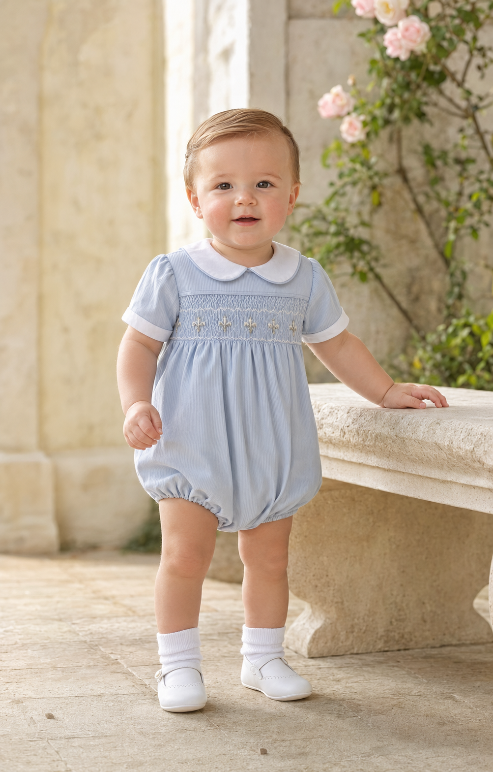 Baby boy wearing a blue smocked bubble romper