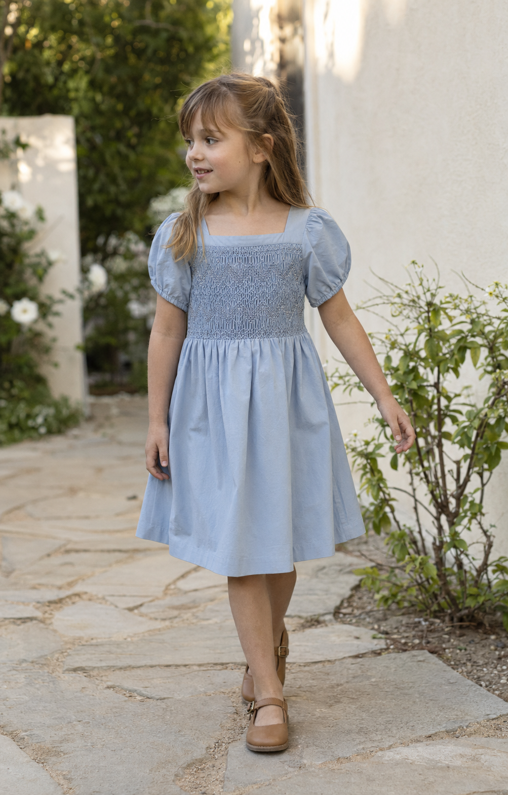 Girl wearing a dusty rose smocked dress for a special occasion